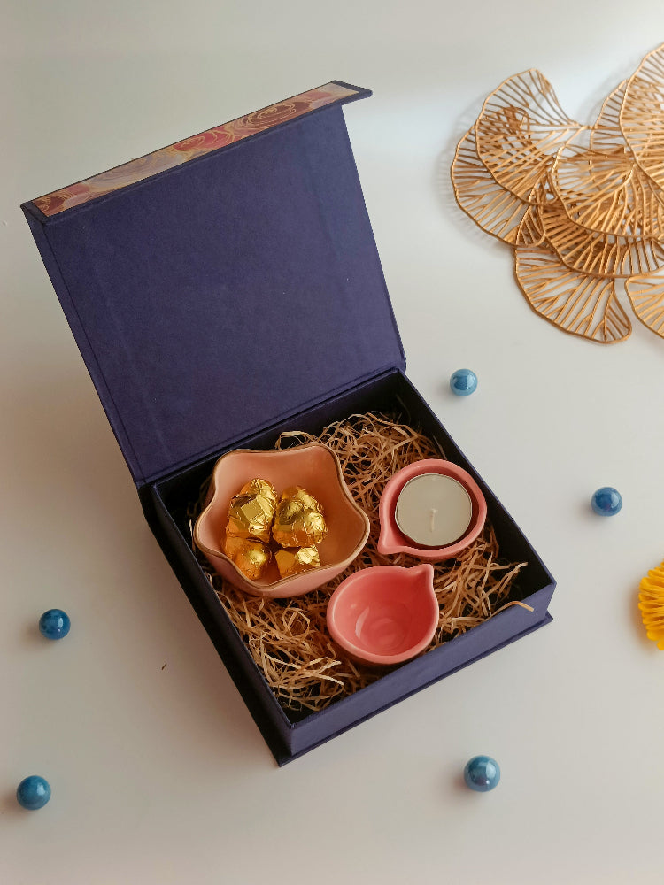 A gift box with ceramic diyas, tealight candle, handmade sweets in a ceramic bowl, a perfect box for ganesh chaturthi, housewarming, diwali and many more occassions.