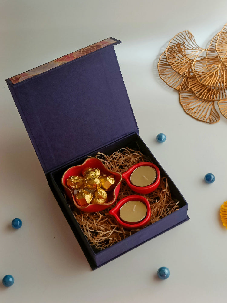 A gift box with ceramic diyas, tealight candle, handmade sweets in a ceramic bowl, a perfect box for ganesh chaturthi, housewarming, diwali and many more occassions.