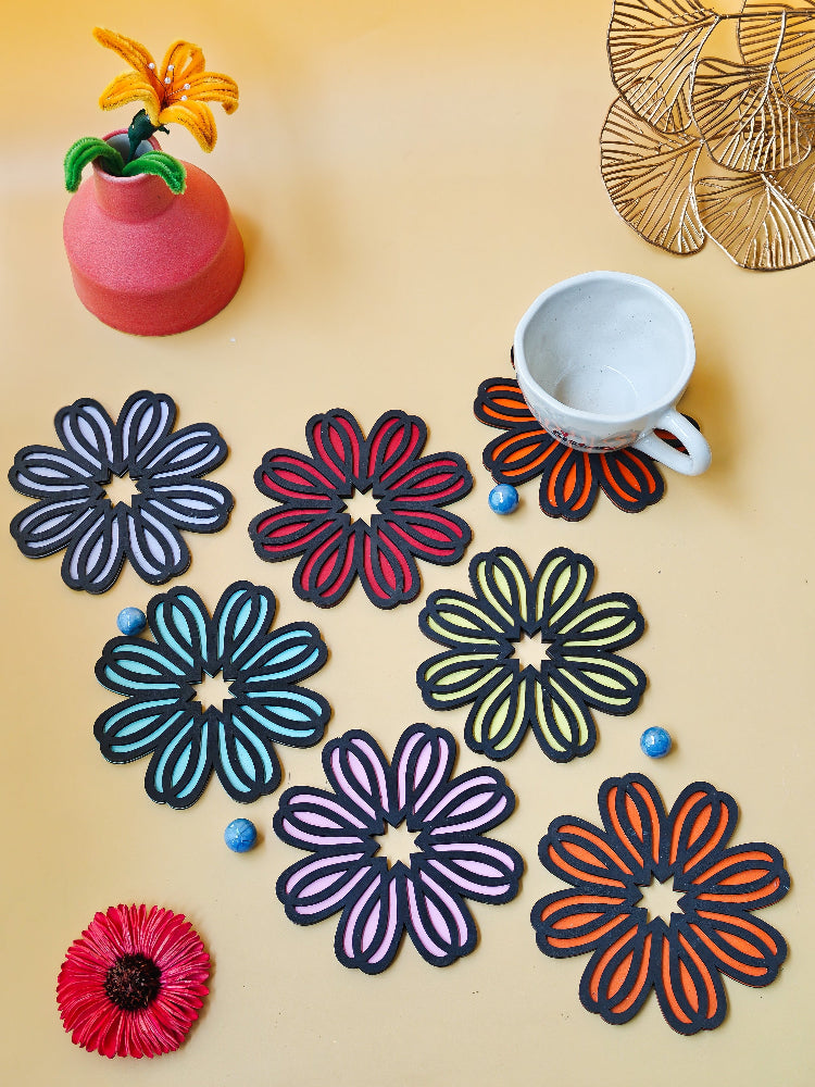 Colorful flower-shaped coasters on a beige surface with a cup and decorative items.